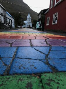 A 10-day Itinerary to Iceland's Ring Road 4 A rainbow road leads to the Blue Church in Iceland. In the middle, there is a bike and a tourist.