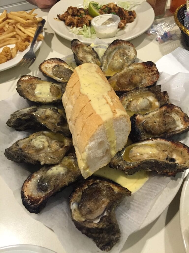 Driving from Texas to Florida? Best Boutique Hotels in New Orleans Off of I-10 2 Chargrilled oysters sit on a plate. A piece of French bread is in the middle. The image is taken from above.