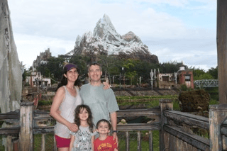 Mount Everest Ride A family stands in front of the Mount Everest ride at Disney World's Animal Kingdom. A large, constructed mountain that resembles Everest stands in the background.